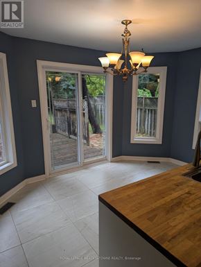 Caledon (Bolton West) apartment for rent - A room with a chandelier and a sliding glass door leading to a backyard.