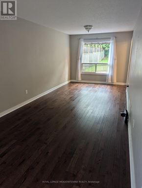 Caledon (Bolton West) apartment for rent - A room with wooden flooring and a window with white curtains.