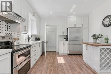 Hamilton townhouse for rent - A modern kitchen with white cabinets and a wooden floor.