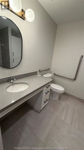 Windsor apartment for rent - A bathroom with a sink, toilet, and mirror.
