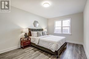 Niagara Falls (Dorchester) apartment for rent - A bedroom with a bed, nightstand, and window.