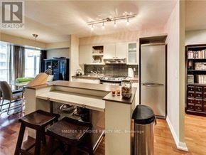 Toronto (Bay Street Corridor) condo for rent - A kitchen with a white island and a refrigerator.