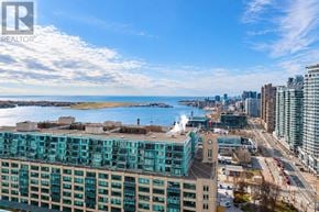 Toronto (Waterfront Communities) condo for rent - A cityscape with a large building in the foreground and a body of water in the background.