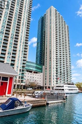 Toronto (Waterfront Communities) condo for rent - A boat is docked in front of a red building and a tall building.