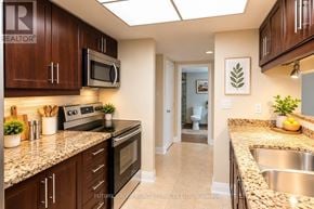 Toronto (Waterfront Communities) condo for rent - A kitchen with brown cabinets and a stove top oven.