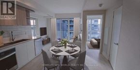 Toronto (Flemingdon Park) condo for rent - A dining room with a table set for two and a kitchen area with white cabinets.