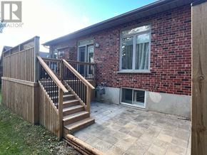 London North (North A) townhouse for rent - A red brick house with a wooden deck and stairs.