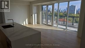 Toronto (Annex) condo for rent - A real estate listing image of a modern kitchen with a view of the city.