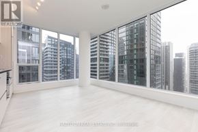 Toronto (Waterfront Communities) condo for rent - A spacious, empty room with a view of the cityscape outside the large windows.