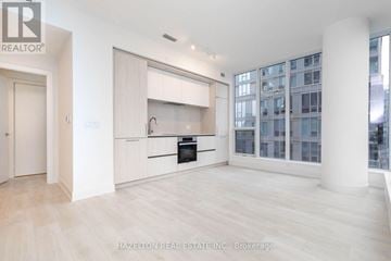 Toronto (Waterfront Communities) condo for rent - A spacious, well-lit kitchen with white cabinets and a large island.