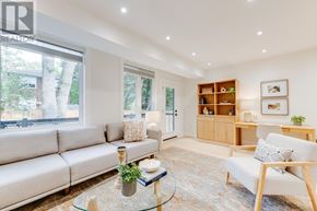 Toronto (Birchcliffe-Cliffside) apartment for rent - A living room with a white sofa, a glass coffee table, and a wooden bookshelf.