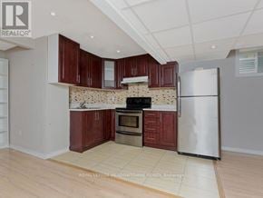 Milton (Co Coates) apartment for rent - A kitchen with wooden cabinets and a white refrigerator.