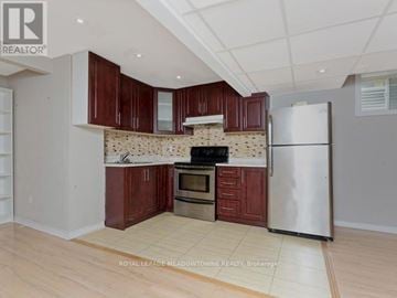 Milton (Co Coates) apartment for rent - A kitchen with wooden cabinets and a white refrigerator.
