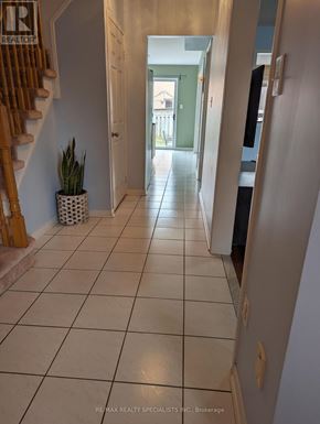 Mississauga (Lisgar) apartment for rent - A hallway with a tiled floor and a wooden staircase.