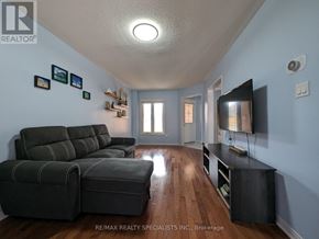 Mississauga (Lisgar) apartment for rent - A living room with a grey sofa and a television.