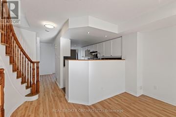 Ottawa townhouse for rent - A spacious kitchen with white cabinets and a wooden staircase.