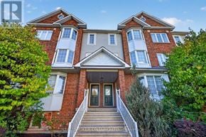 Ottawa townhouse for rent - A red brick house with a front porch and a tree in front.