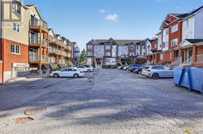 Ottawa townhouse for rent - A parking lot with cars and apartment buildings in the background.