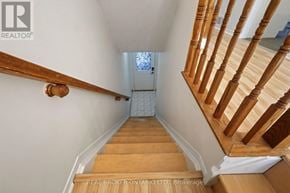 Ottawa townhouse for rent - A wooden staircase with a white wall on the side.