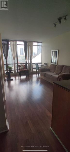 Toronto (Waterfront Communities) condo for rent - A living room with a couch and a chair.