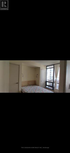 Toronto (Waterfront Communities) condo for rent - A bedroom with a bed, a window with curtains, and a door.