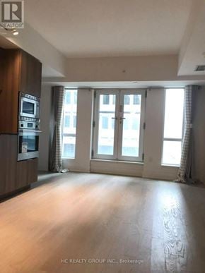Toronto (Bay Street Corridor) condo for rent - A spacious room with a kitchen area and large windows.