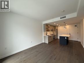 Vancouver apartment for rent - A large empty room with a kitchenette in the corner.