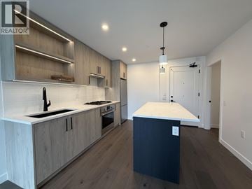 Vancouver apartment for rent - A modern kitchen with wooden cabinets and a black island.