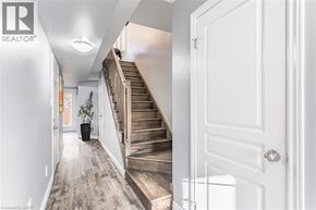 Stoney Creek townhouse for rent - A hallway with a staircase and a door on the right.