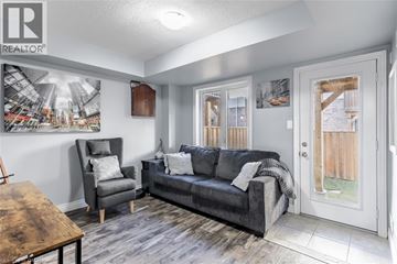 Stoney Creek townhouse for rent - A living room with a grey couch and a wooden table.