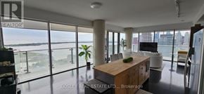 Toronto (Waterfront Communities) condo for rent - A spacious living room with a view of the water and a balcony.