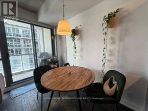 Toronto (Waterfront Communities) condo for rent - A room with a table and chairs and a hanging plant.