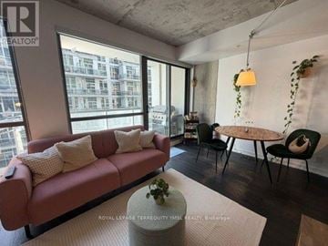 Toronto (Waterfront Communities) condo for rent - A living room with a red couch and a round table.