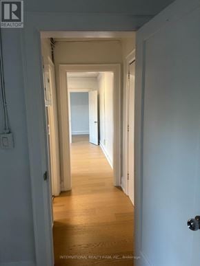Toronto (Dufferin Grove) multi-family for rent - A hallway with white walls and wooden floors.