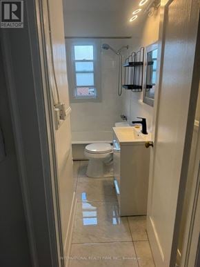 Toronto (Dufferin Grove) multi-family for rent - A white toilet in a small bathroom with a shower.