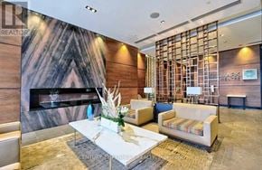 Toronto (Willowdale East) condo for rent - A living room with a fireplace and a sofa.