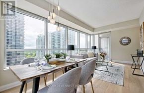 Toronto (Willowdale East) condo for rent - A dining room with a wooden table set for two with a view of the city.