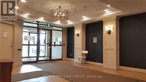 Brampton (Fletcher's Creek South) condo for rent - A brokerage office with a chandelier and a green exit sign.