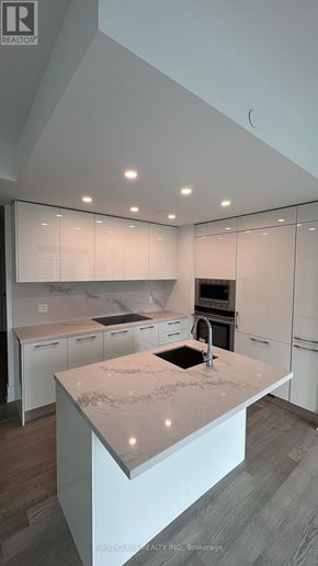 Toronto (Church-Yonge Corridor) condo for rent - A modern kitchen with white cabinets and a marble island.