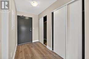 South Dundas condo for rent - A hallway with a black door and white walls.