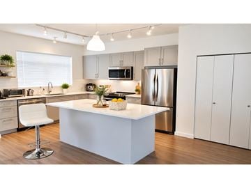 Surrey townhouse for rent - A modern kitchen with a white island and stainless steel appliances.