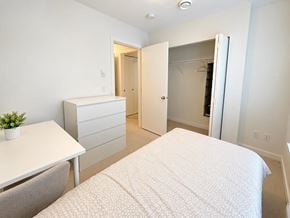 Surrey townhouse for rent - A bedroom with a bed, dresser, and table.