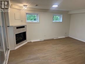 Toronto (Lansing-Westgate) apartment for rent - A room with a fireplace and two windows.