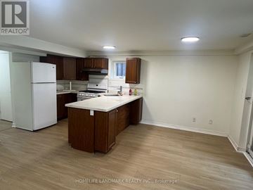 Toronto (Lansing-Westgate) apartment for rent - A kitchen with a white fridge and wooden cabinets.