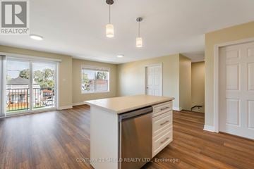 Cornwall triplex for rent - A kitchen with wooden floors and white cabinets is shown.