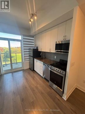 Toronto (Tam O'shanter-Sullivan) condo for rent - A modern kitchen with stainless steel appliances and wooden flooring.