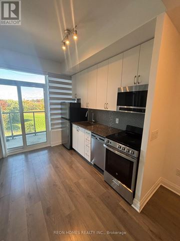 Toronto (Tam O'shanter-Sullivan) condo for rent - A modern kitchen with stainless steel appliances and wooden flooring.