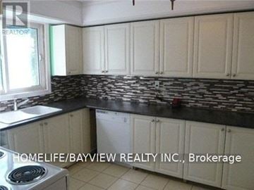 Richmond Hill (South Richvale) apartment for rent - A kitchen with white cabinets and a black counter top.