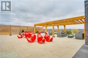 Burlington (Mountainside) condo for rent - A patio area with red chairs and a wooden pergola.