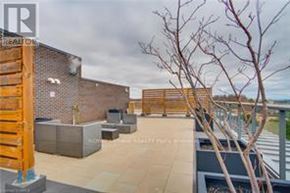 Burlington (Mountainside) condo for rent - A rooftop patio with a wooden fence and a tree.